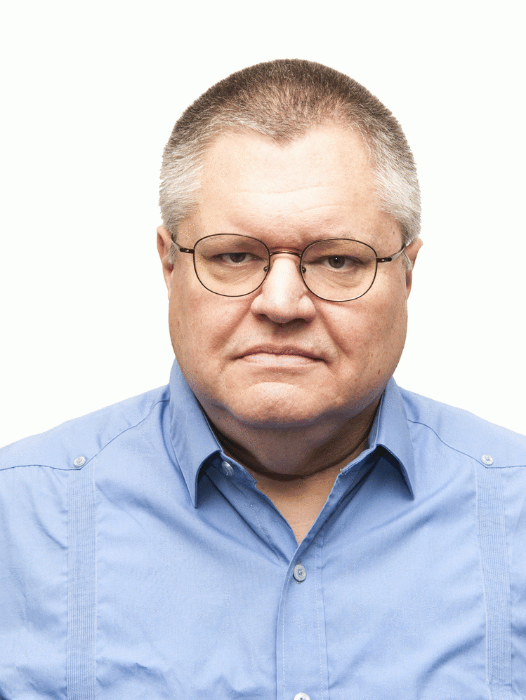 A headshot of Raúl Sánchez. He is wearing a light blue dress shirt and glasses.