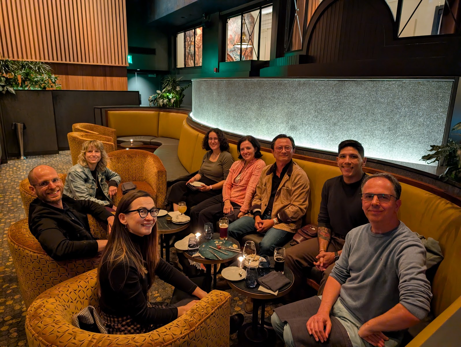 Eight Laurance S. Rockefeller Visiting Faculty Fellows are seated at an upscale dining booth at Princeton's University Center for Human Values.